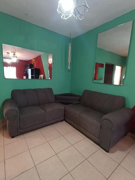 ein Wohnzimmer mit Sofa und Spiegel in der Unterkunft Casa texcoco in Cabo San Lucas