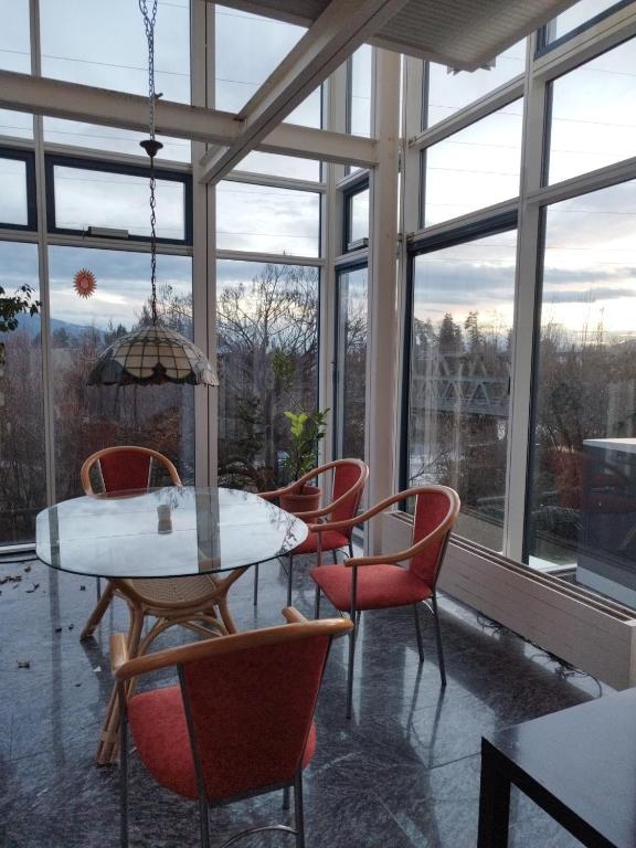 a dining room with a table and chairs and windows at 100qm - Räumlichkeiten, Bregenz am Bodensee in Bregenz