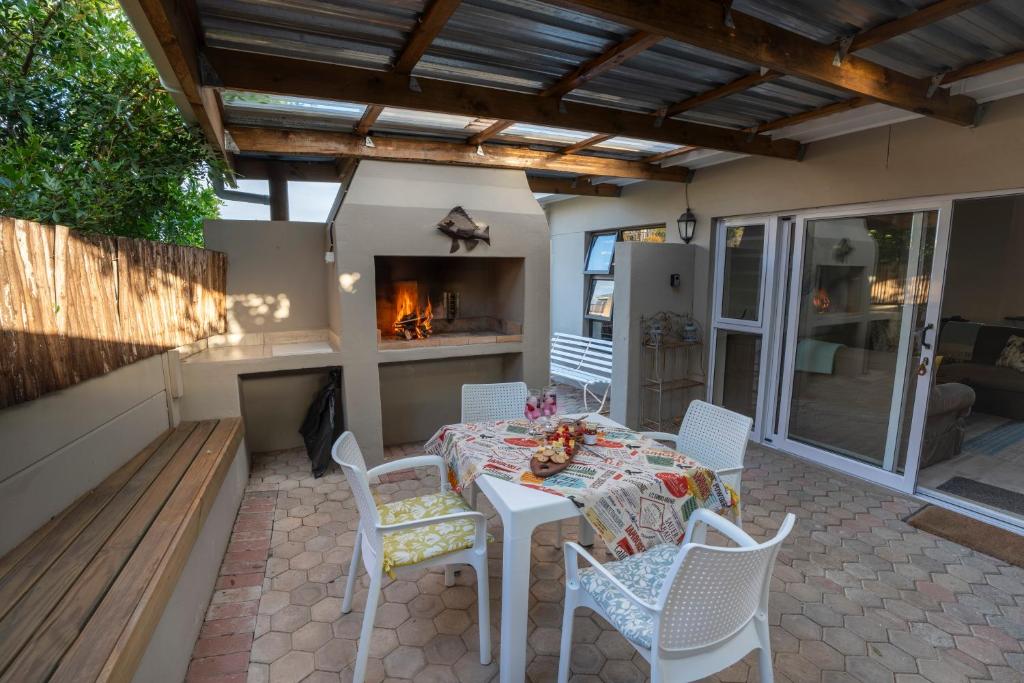 莫塞尔湾The Barefoot Cottage的带桌椅和壁炉的露台