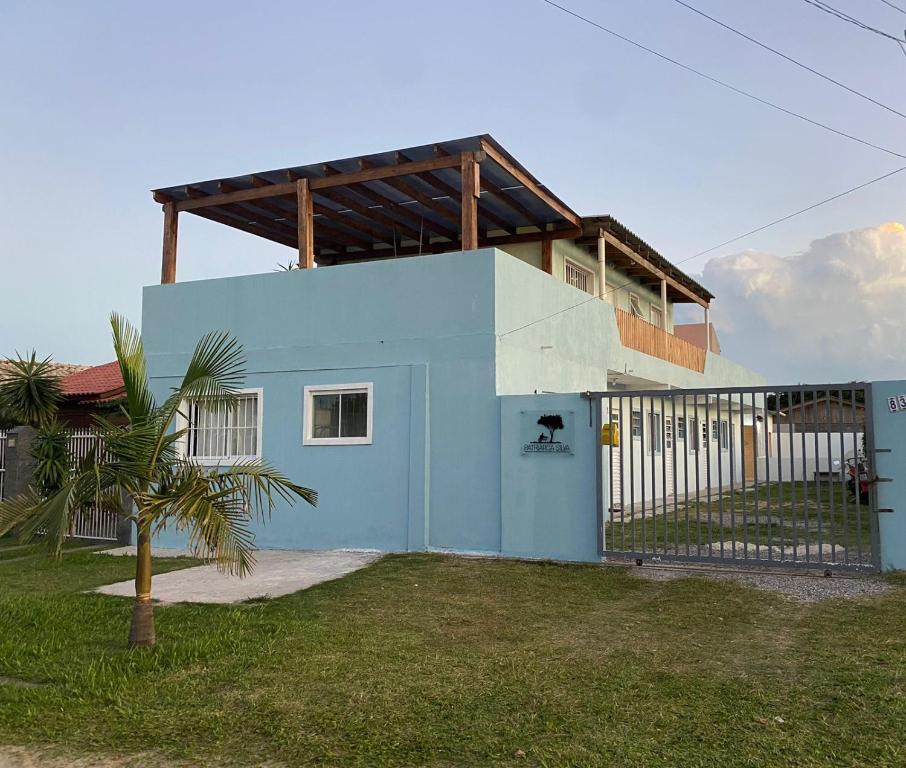 Una casa azul y blanca con un árbol delante. en Pousada Patriarca Silva, en Río Grande