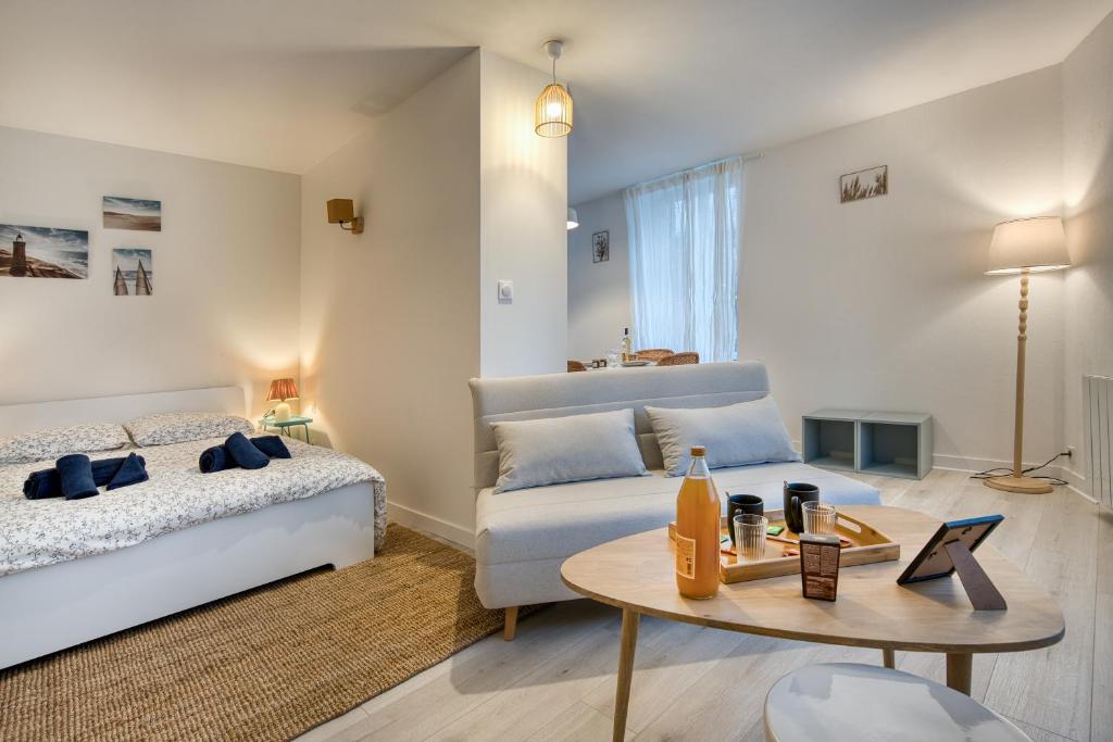 une chambre avec un lit, une table et un canapé dans l'établissement Apparts hôtels Concarneau, à Concarneau