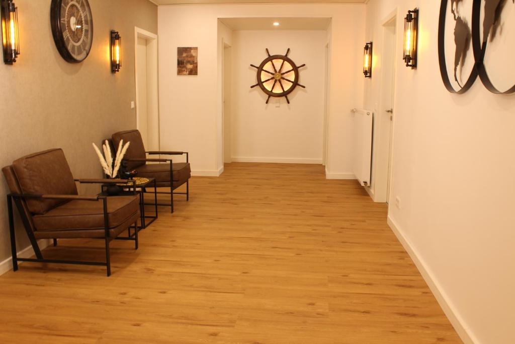 a hallway with chairs and a clock on the wall at Ferienwohnung Familie Renner in Cappel-Neufeld