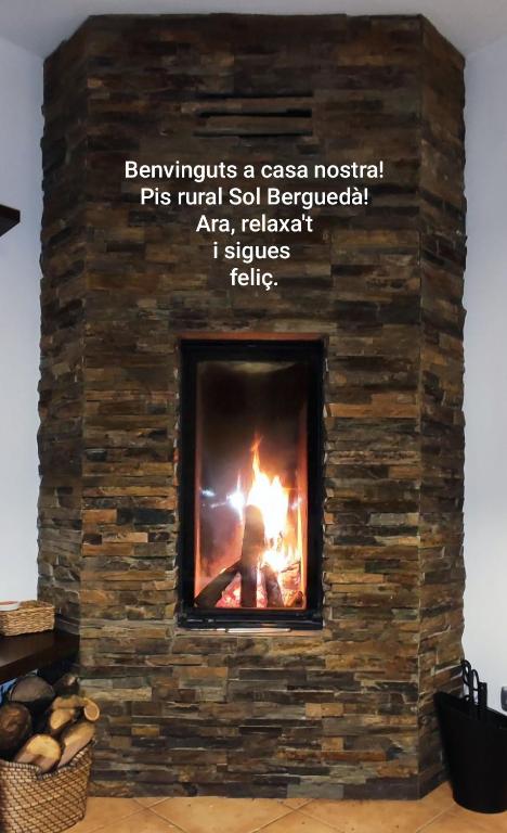 a brick fireplace with a fire in it at Piso rural Sol Berguedà in Aviá
