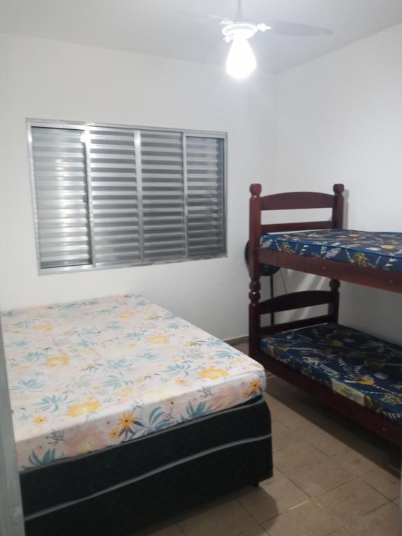 a bedroom with two bunk beds and a window at Casa com vista para o mar! in Peruíbe
