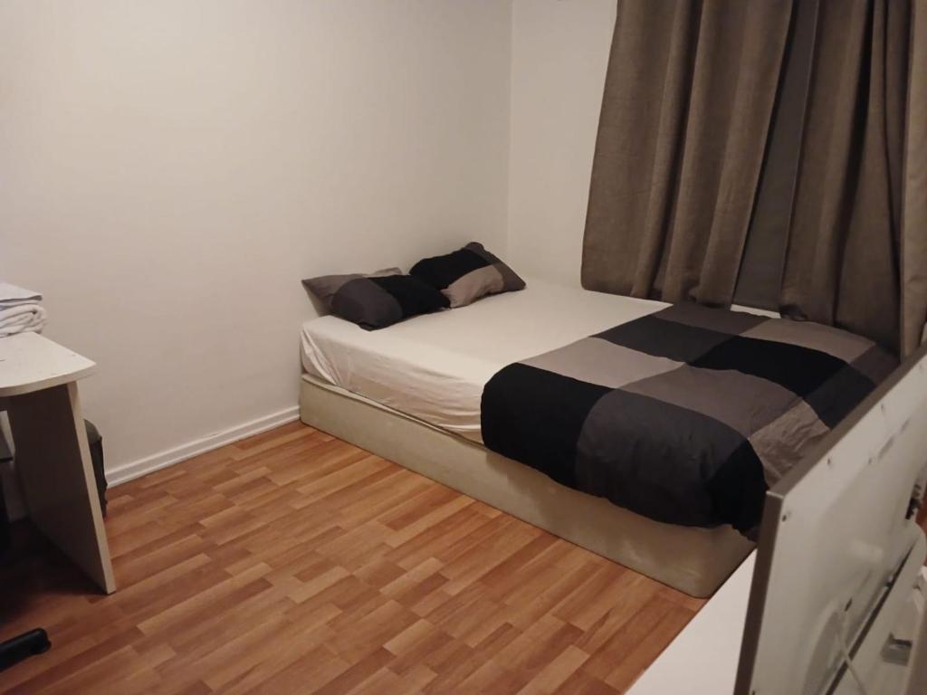 Ce petit lit se trouve dans un dortoir doté de parquet. dans l'établissement CHARLISE APARTMENTs, à Oslo