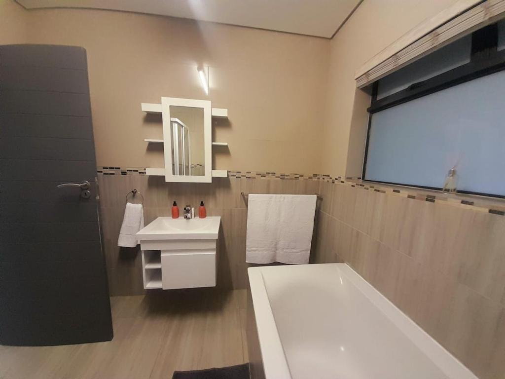a bathroom with a tub and a sink and a bath tub at Kidd's Beach in Kiddʼs Beach