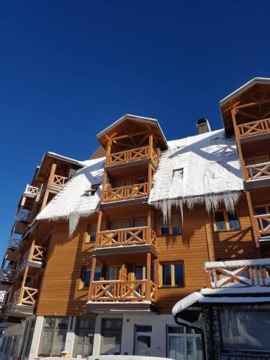 a tall building with snow on the top of it at Apartman 151 U u Aparthotelu Vučko Jahorina - private host in Jahorina