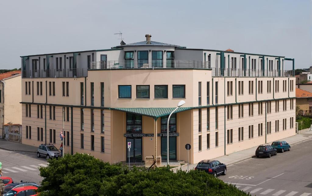 a large building with cars parked in a parking lot at L'incanto Di Boccadarno in Marina di Pisa