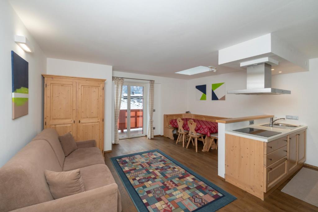a kitchen and living room with a couch and a sink at Casa Chatrian in Moena