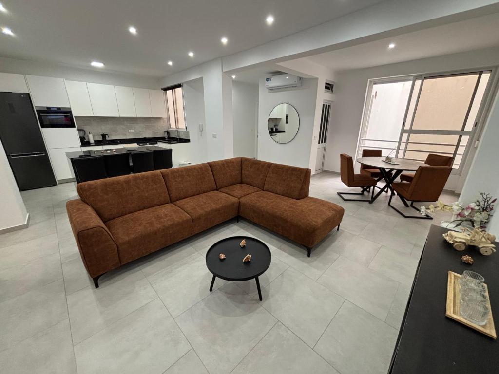 een woonkamer met een bruine bank en een tafel bij Urban Mindelo in Mindelo