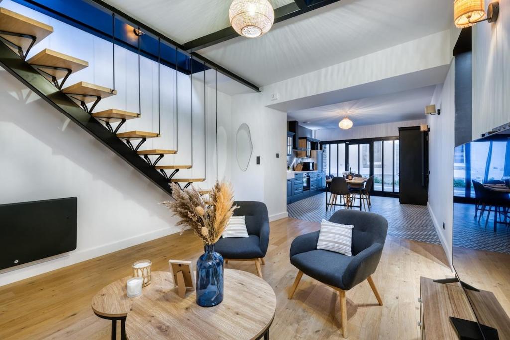- un salon avec un escalier, une table et des chaises dans l'établissement Ocean Blue, à Concarneau
