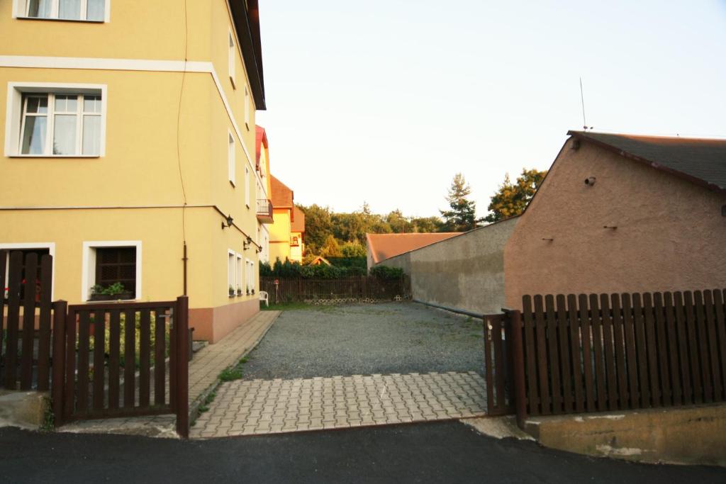 a building with a fence next to a house at Diamant in Karlovy Vary