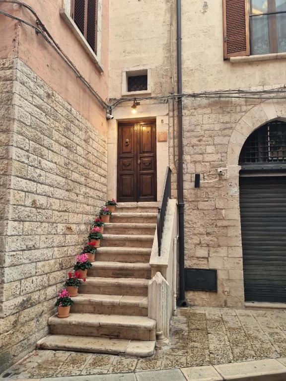 a set of stairs leading to a door with flowers at Casa di Orazio in Barletta