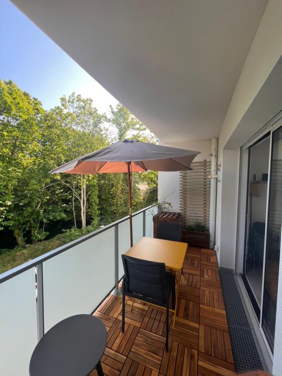 - un balcon avec un parasol, une table et des chaises dans l'établissement Men Konk, à Concarneau
