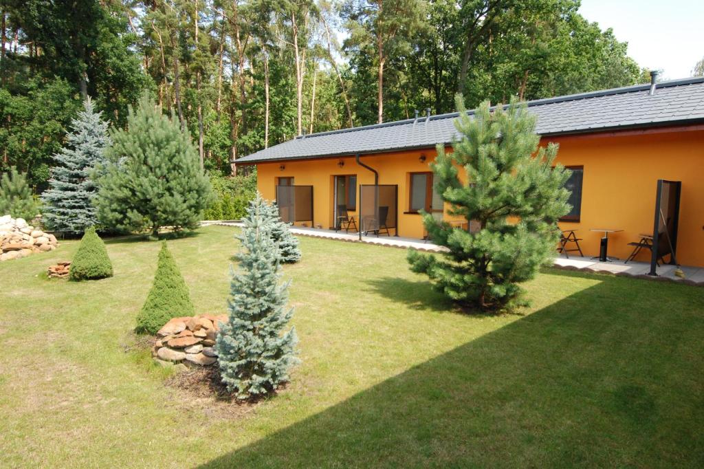 a house with trees in front of a yard at Apartmány Stříbrňák in Hradec Králové