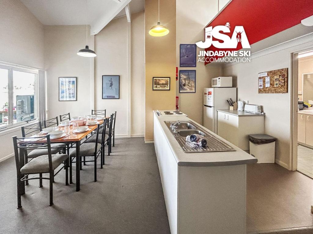 a kitchen and dining room with a long table with chairs at Razorback 2 in Jindabyne