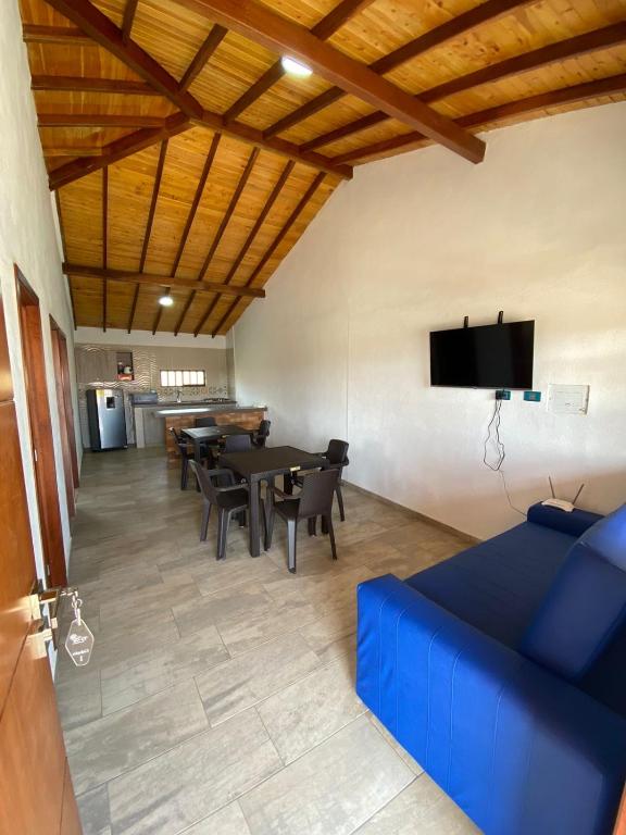 Cabañas El Sol في بيديكويستا: غرفة معيشة مع أريكة زرقاء وطاولة