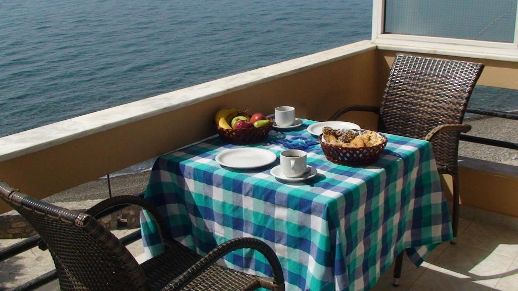 una mesa con dos sillas y una mesa con comida. en Lyttos, en Tsoutsouros