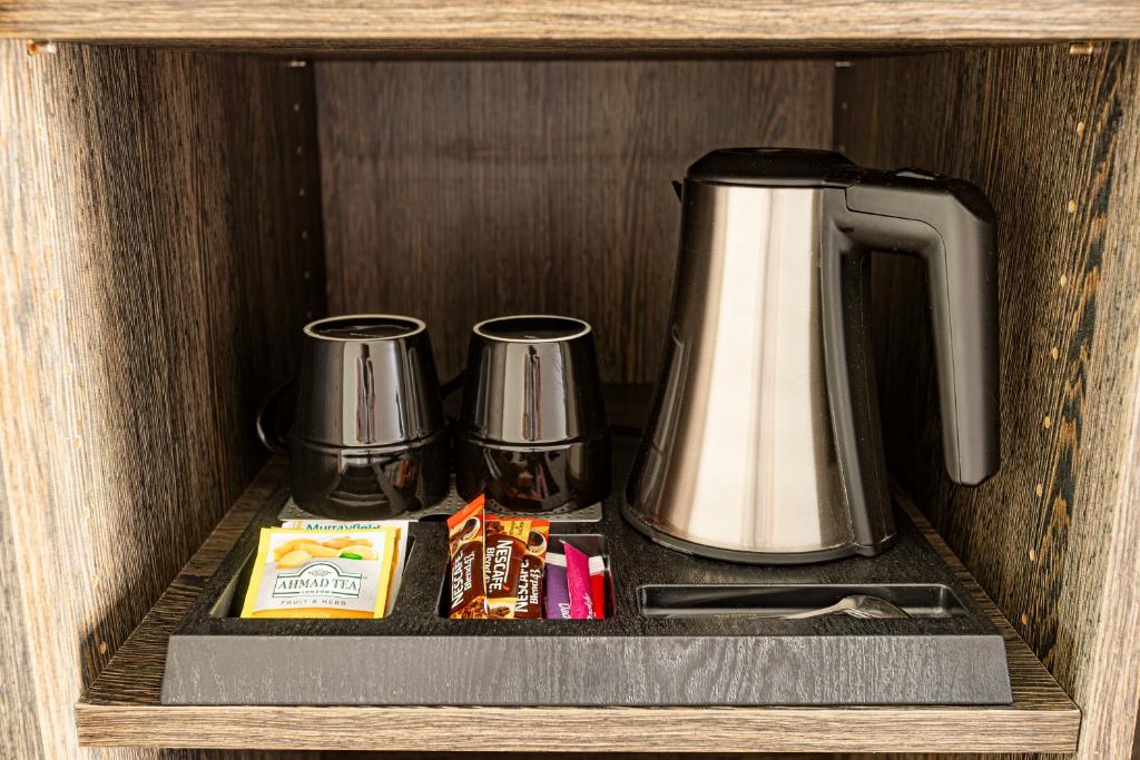 a cupboard with a coffee maker and a tea kettle at Hotel Beaurivage in Noumea