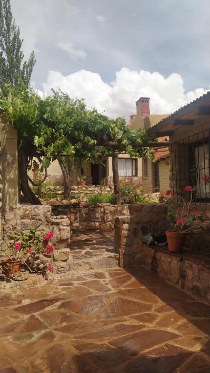 a courtyard with a stone wall and a tree at ENTRECERROS, Tilcara in Tilcara
