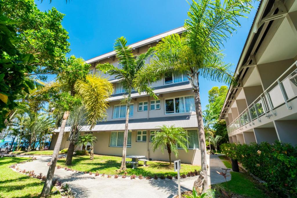 a building with palm trees in front of it at Hotel Beaurivage in Noumea