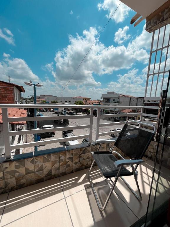 a chair on a balcony with a view of a parking lot at Flat Terra do Sol - Jijoca in Jijoca de Jericoacoara
