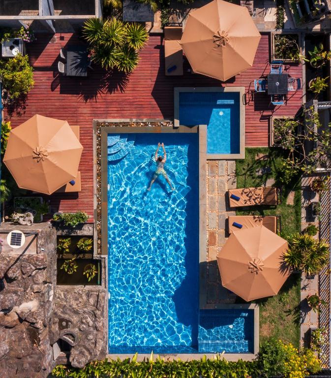 シェムリアップにあるSIEM REAP RIVER VIEW Residenceのパラソル付きのスイミングプールのオーバーヘッドビュー