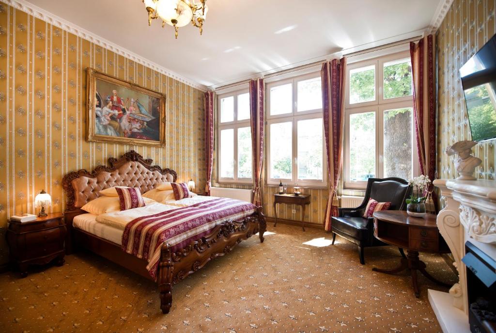 1 dormitorio con 1 cama, 1 silla y ventanas en Guest house Villa Fritz, en Potsdam