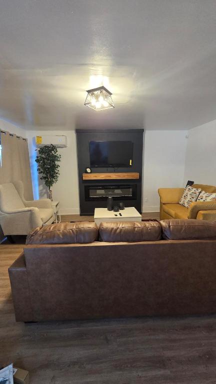 a living room with a couch and a flat screen tv at Luxury 4 Bedroom Modern Escape in Detroit