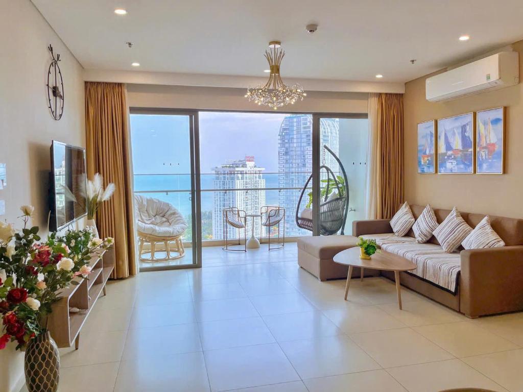 a living room with a couch and a large window at The Sóng Apartment Vũng Tàu - Căn Hộ Hồ Bơi-Olive Homestay in Vung Tau