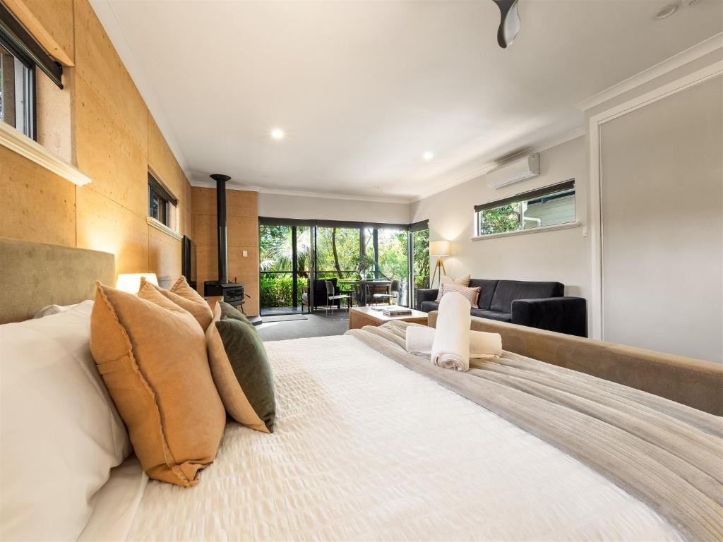 Un dormitorio con una cama grande y una sala de estar. en Aroha, en Margaret River Town