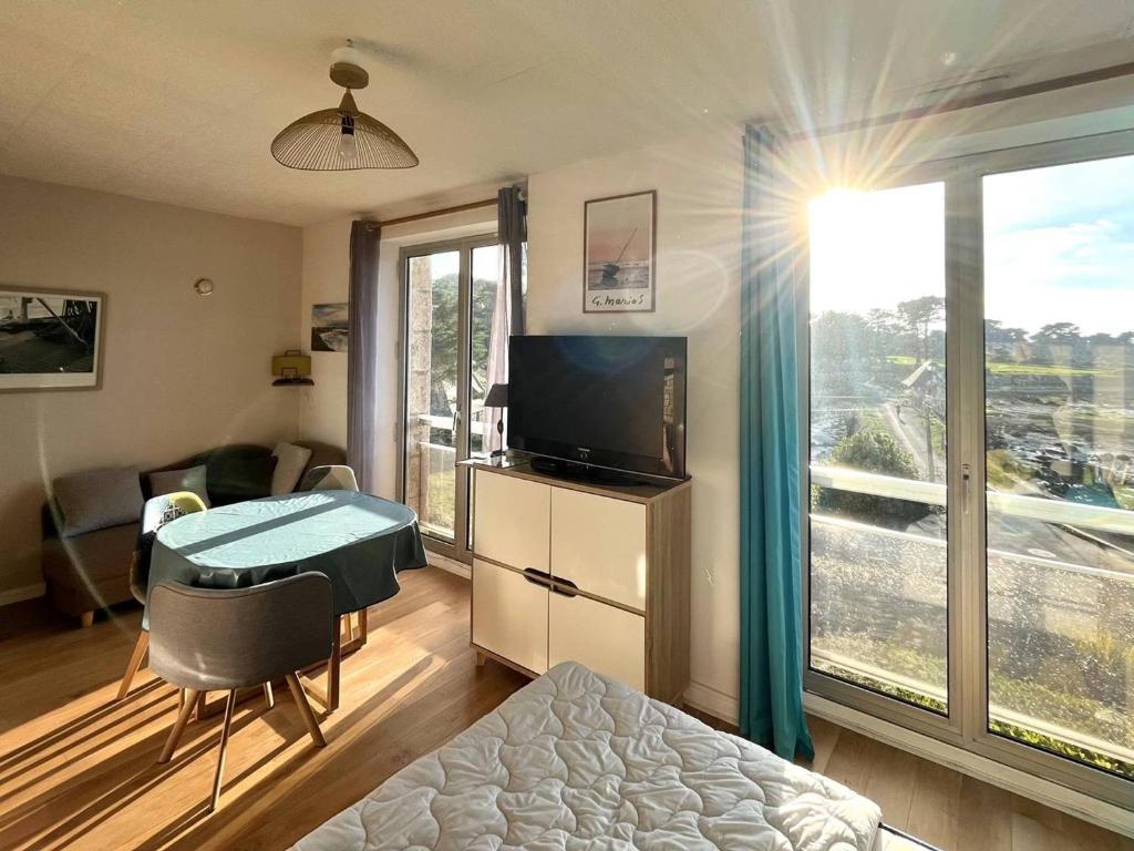 une chambre avec un lit, une télévision et une fenêtre dans l'établissement Studio cosy pour 2 pers. avec parking à Perros-Guirec, près de la plage St Guirec - FR-1-368-436, à Perros-Guirec