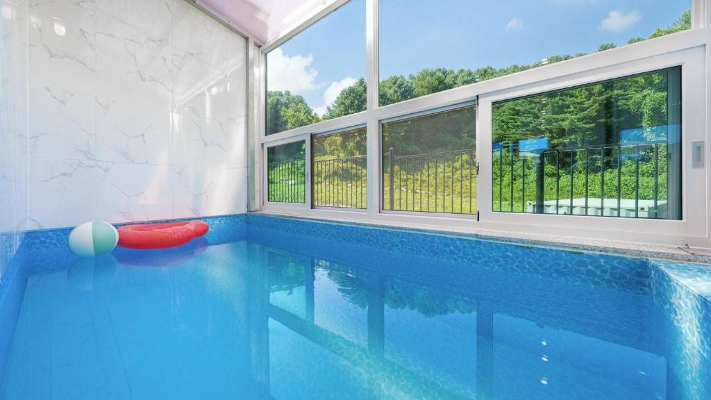 - une piscine avec un ballon rouge au milieu dans l'établissement Gapyeong staysumok pool villa pension, à Gapyeong