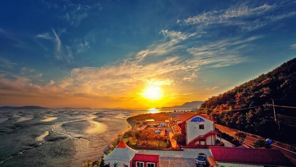 an aerial view of a sunset over the ocean at Ganghwa Granblue Pension in Incheon