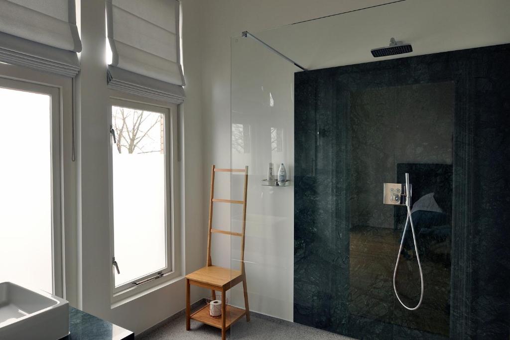 een badkamer met een douche, een wastafel en een douche bij Boetiek Hotel Kampen in Kampen