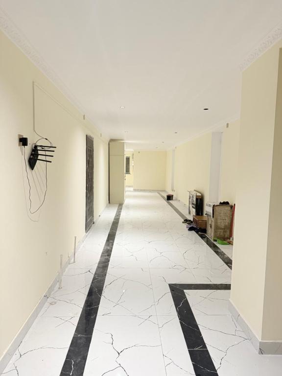 巴库Rova Hostel的空的走廊,有白色的墙壁和黑白的地板