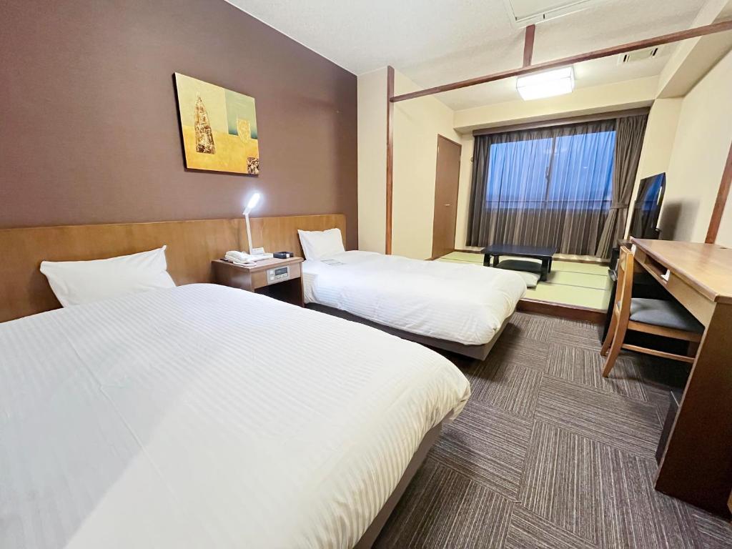 Postel nebo postele na pokoji v ubytování Route Inn Grantia Hidatakayama Wakura no yado