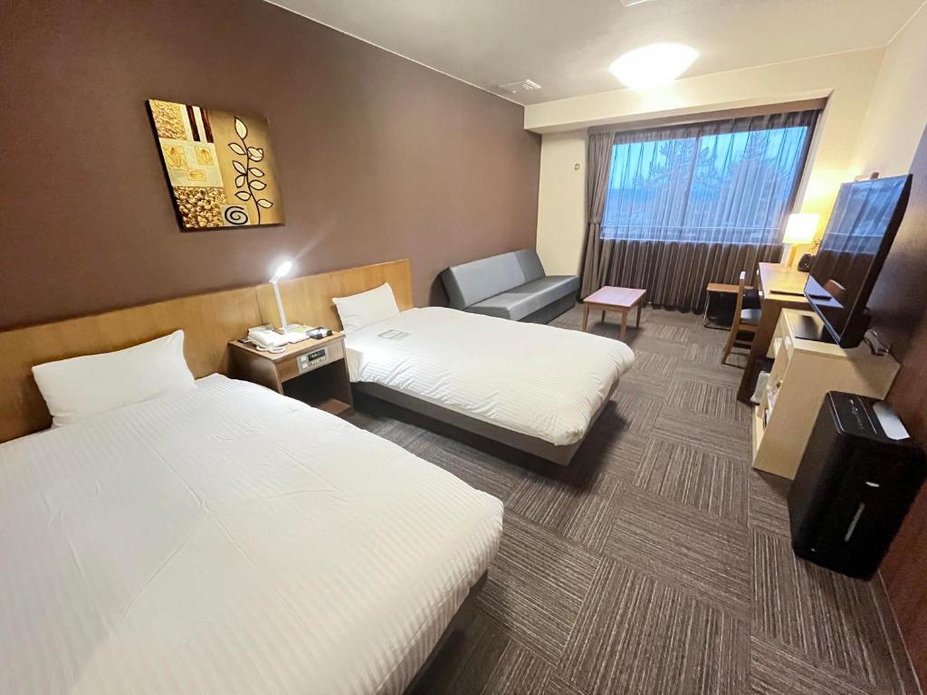 Postel nebo postele na pokoji v ubytování Route Inn Grantia Hidatakayama Wakura no yado