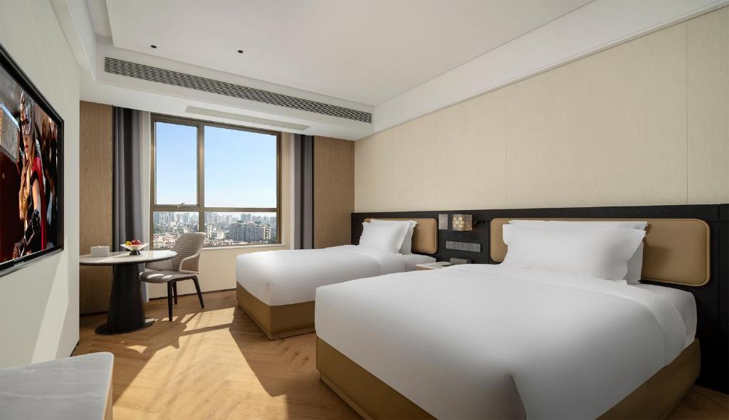 Mehood Lestie International Hotel Panyu Flagship Branch - Free Shuttle Bus to Canton Fair Complex During Canton Fair Period & Free Breakfast & Free Afternoon Tea & Free Midnight Snack客房内的一张或多张床位