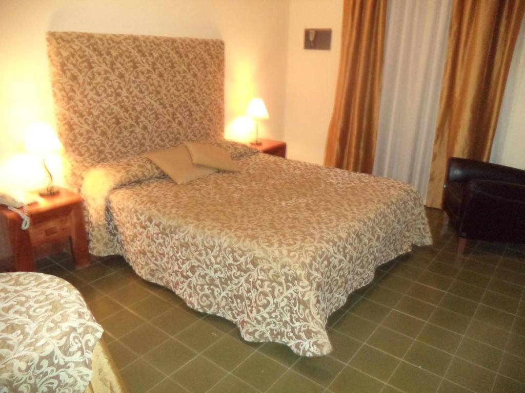 a hotel room with a bed and two lamps at Hotel Scala Greca in Syracuse