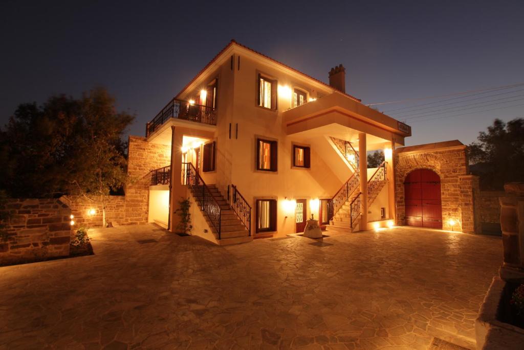 a large house with a courtyard at night at Avgerinos Hotel in Kambos