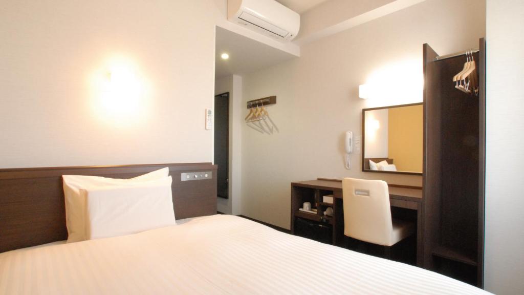 una camera d'albergo con un letto e una scrivania di AB Hotel Kakamigahara a Kakamigahara
