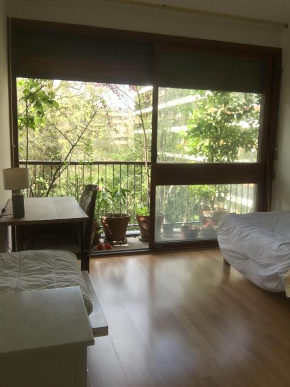 - une chambre avec un balcon doté d'un lit et d'une table dans l'établissement Gardens, Pool and More !, à La Celle-Saint-Cloud