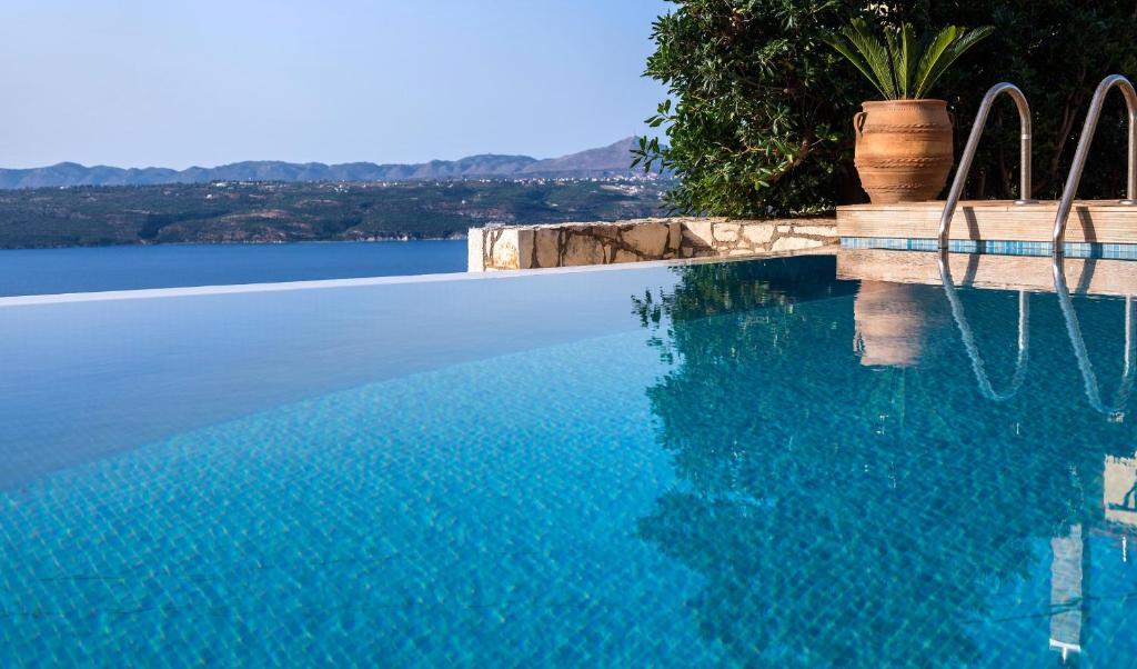Megála KhoráfiaにあるVilla Majestic Crete heated pool and saunaの水辺の景色を望むスイミングプール