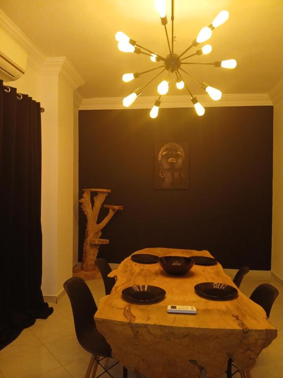 a dining room with a wooden table and a chandelier at Hurghada HOME in Hurghada