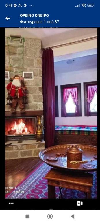 阿尼利奧迈措翁ΟΡΕΙΝΟ ΟΝΕΙΡΟ的带壁炉和桌子的客厅