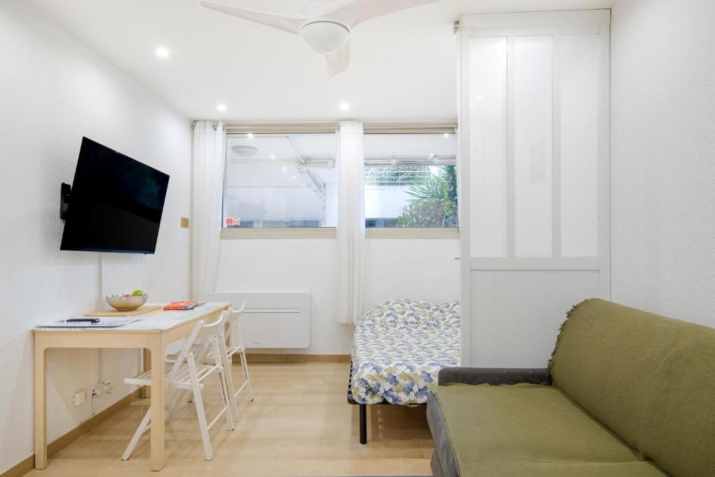 een woonkamer met een bank, een tafel en een bureau bij Studio - 2 couchages doubles in Villeneuve-Loubet