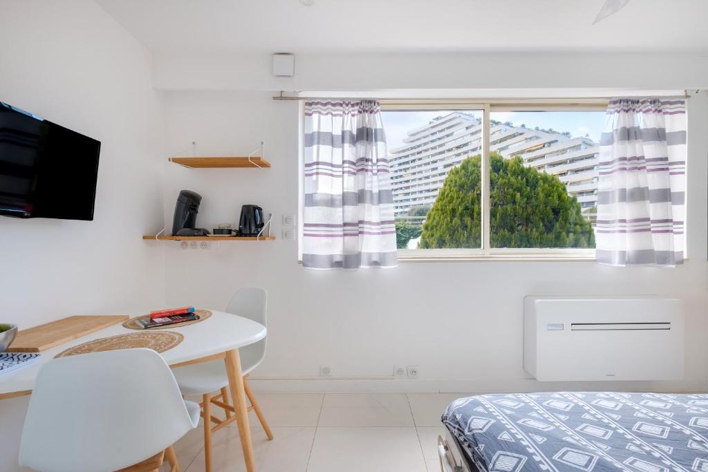une chambre avec un lit, une table et une fenêtre dans l'établissement Studio Ensoleillé - Marina Baie, à Villeneuve-Loubet