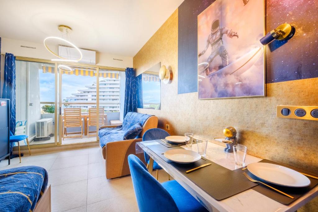 une salle à manger avec une table et des chaises bleues dans l'établissement Studio pour 4 - balcon vue mer, à Villeneuve-Loubet