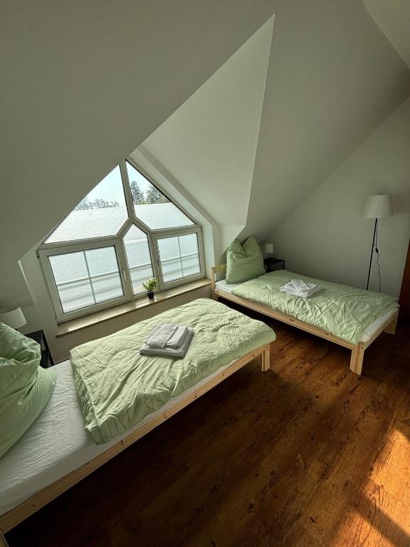 two beds in a attic room with a window at Wohnung mit Galerie in Prenzlau